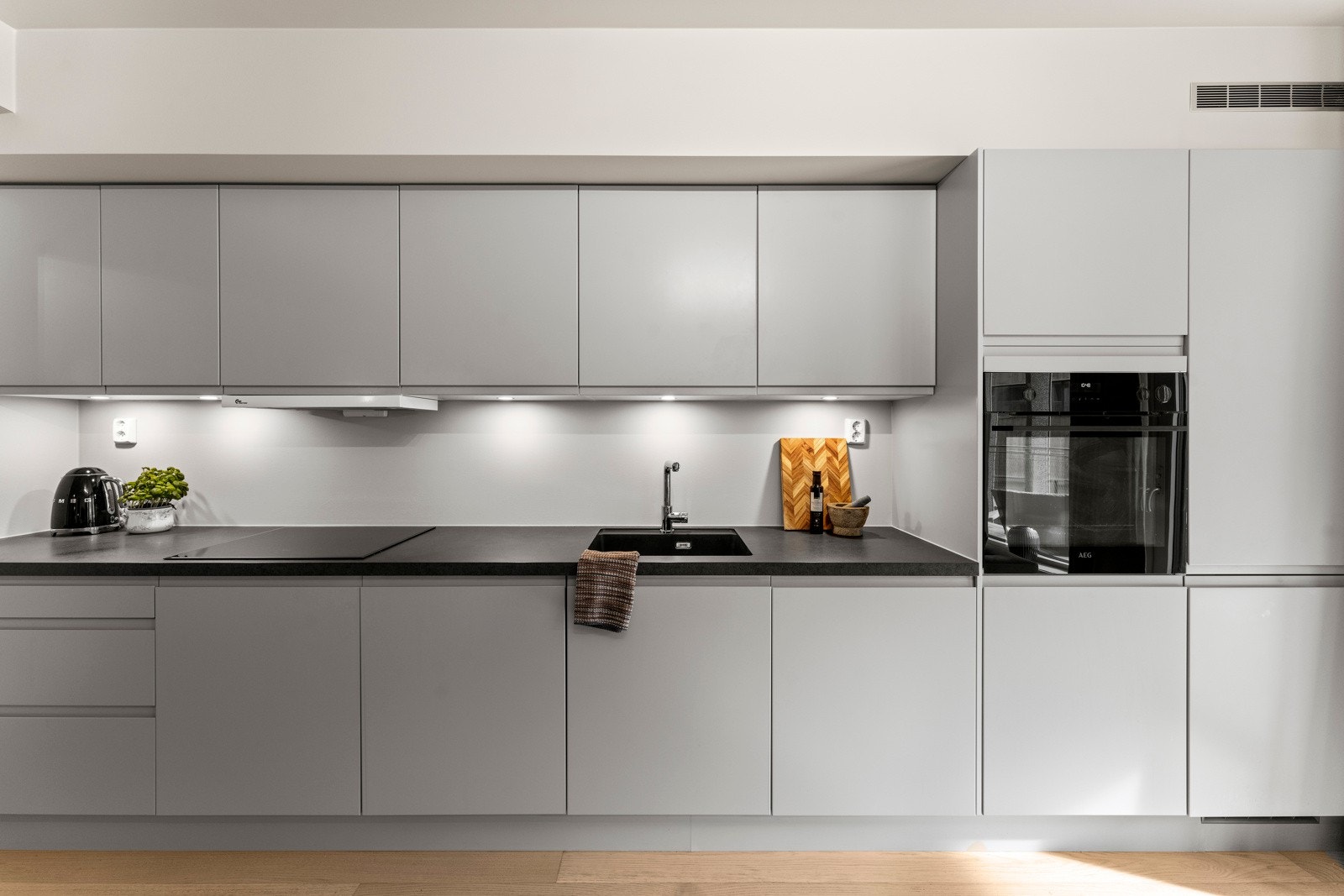 Kjøkkenet har en stilren og moderne utforming, med slette fronter, laminat benkeplate. Galleribilde