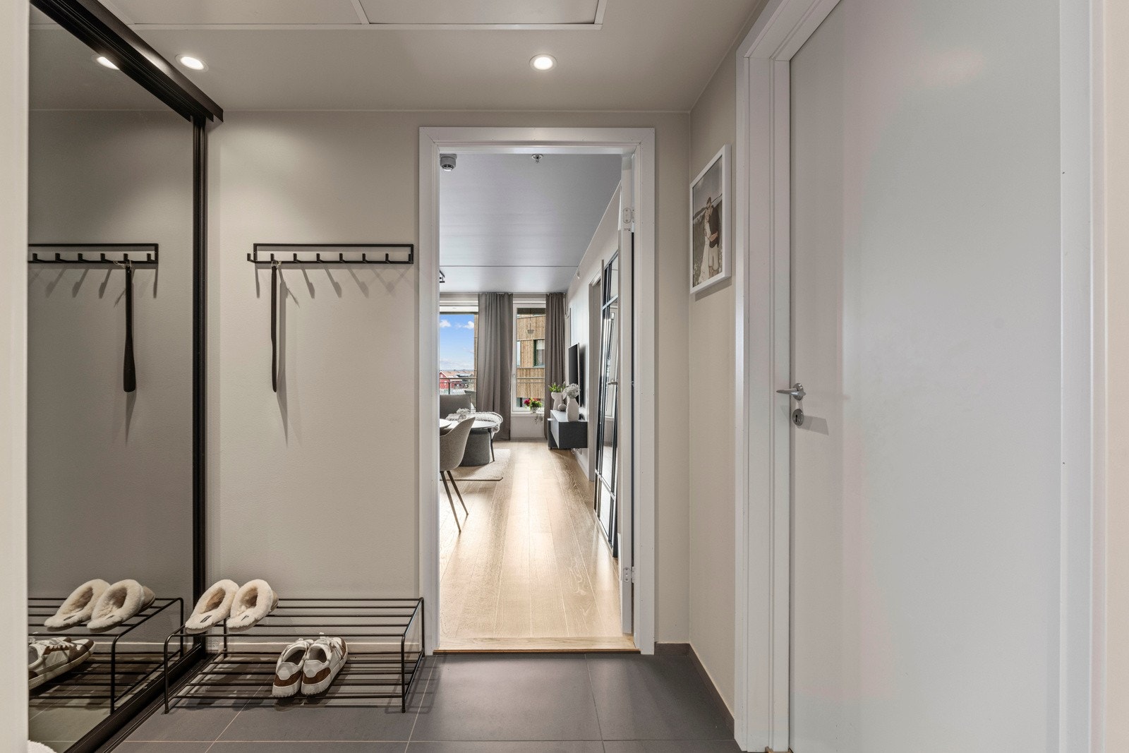 Innenfor døren møtes du av en ryddig entré med slette, malte vegger og flislagt gulv med vannbåren varme - et praktisk og behagelig førsteinntrykk.. Galleribilde