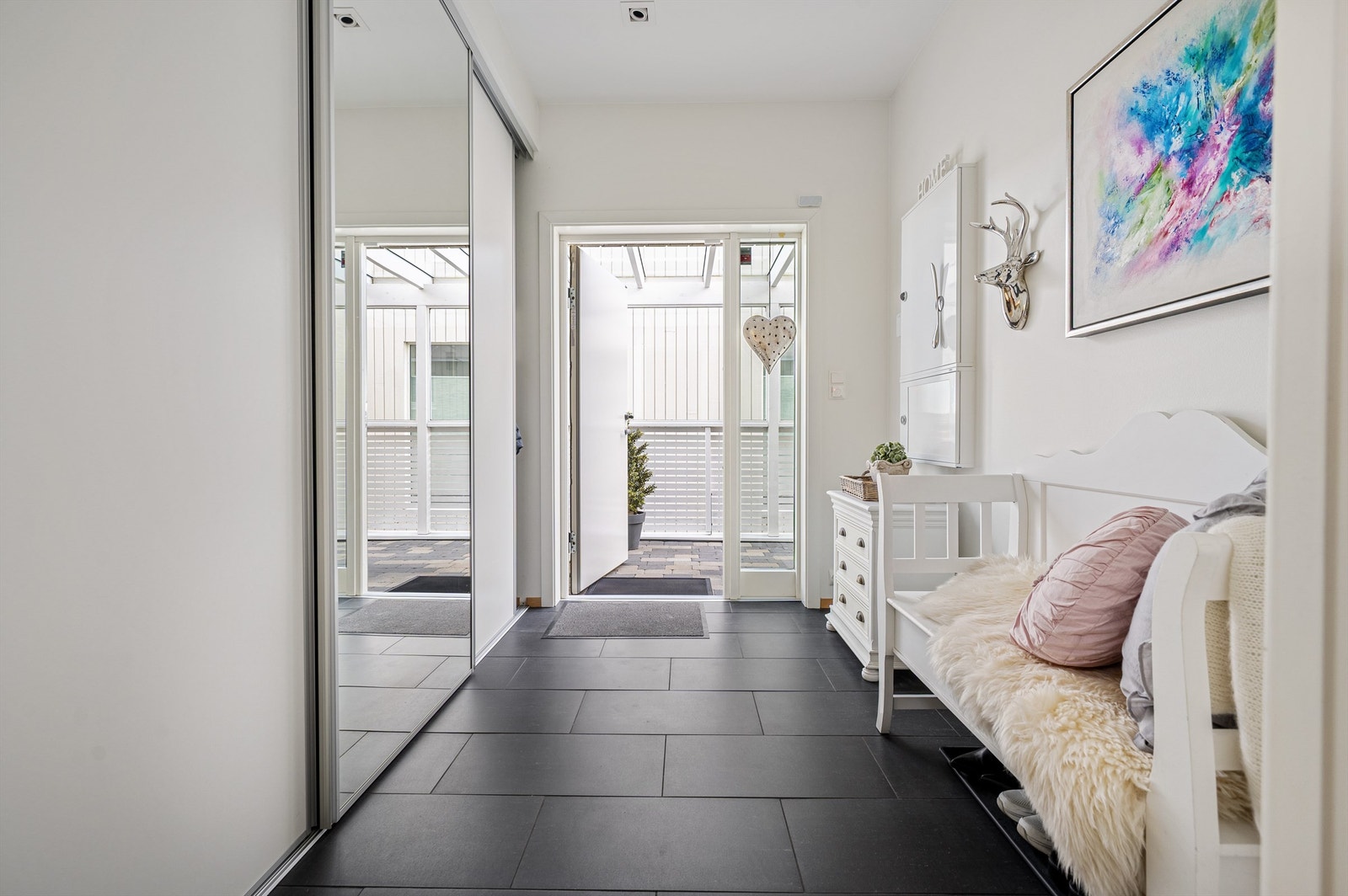 Gangen har slitesterke fliser på gulvet og skyvedørsgarderobe med speildør Galleribilde