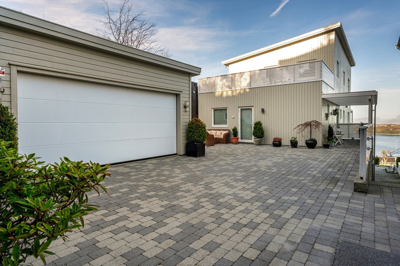 Utearealet bak huset er steinsatt og den doble garasjen har intern bod. Galleribilde