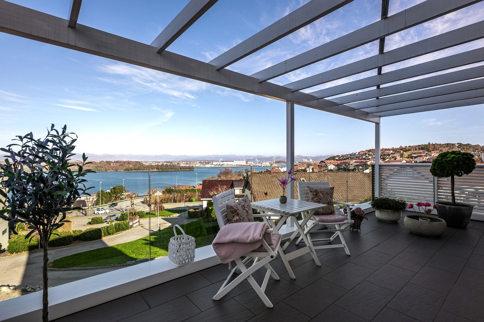 Terrassen er fliselagt og har pent glassrekkverk for å maksimere utsikten Galleribilde