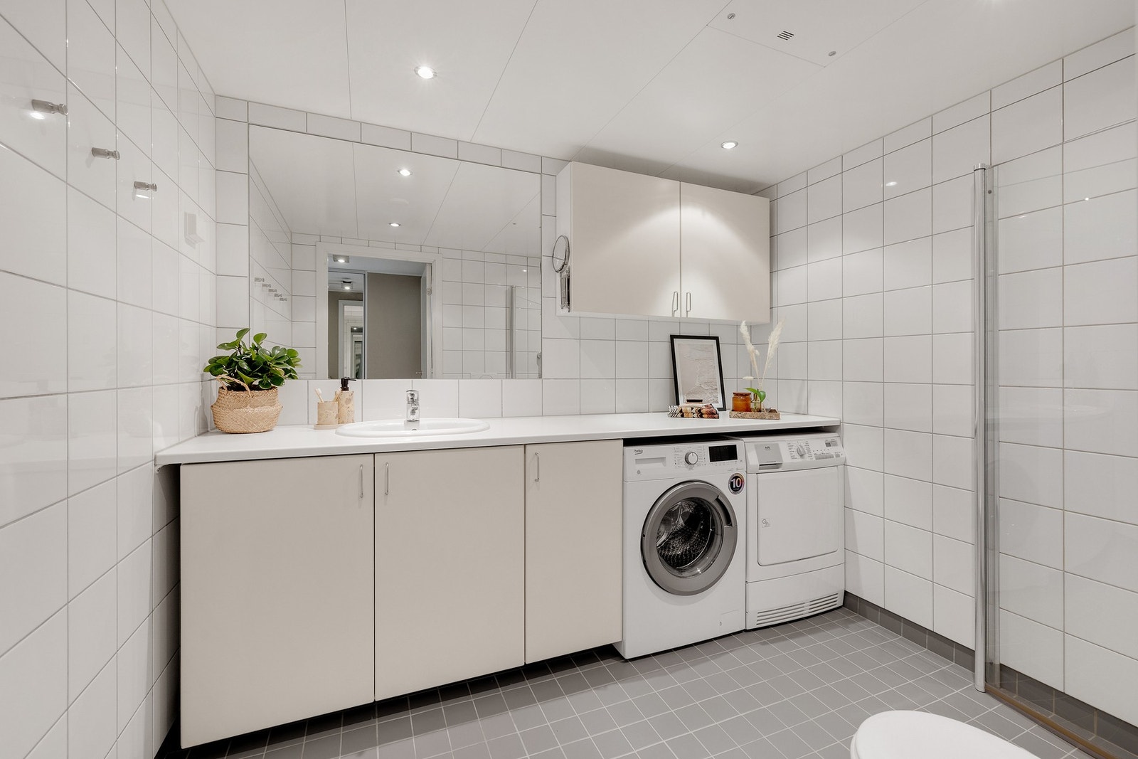 Lekkert bad med stort speil og meget gode oppbevaringsmuligheter i over og underskap. Galleribilde