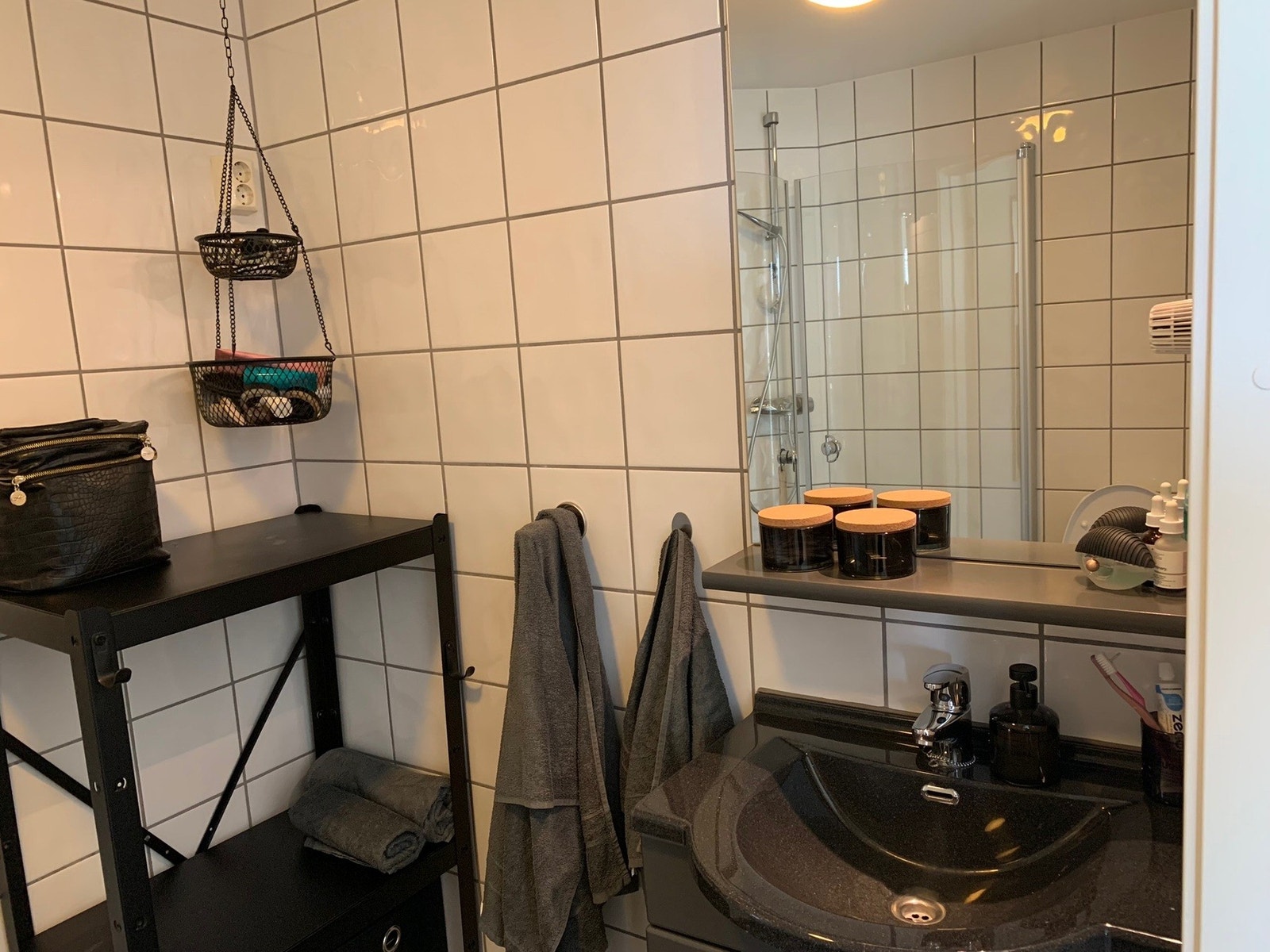 Moderne og praktisk bad med stilrent dusjhjørne. Opplegg for vaskemaskin for enkel hverdag. Rørskap sikrer ryddig installasjon. Elegant baderomsinnredning med servant, underskap og speil. Galleribilde