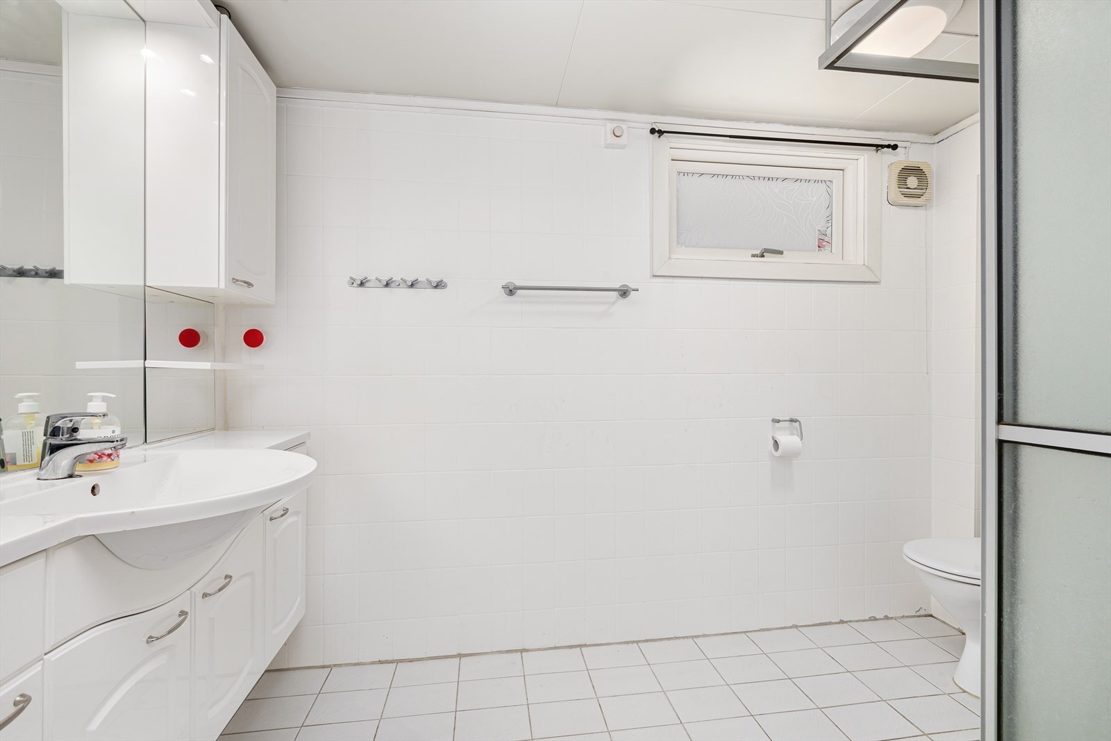 Flislagt bad med vegghengt innredning, dusj og toalett Galleribilde