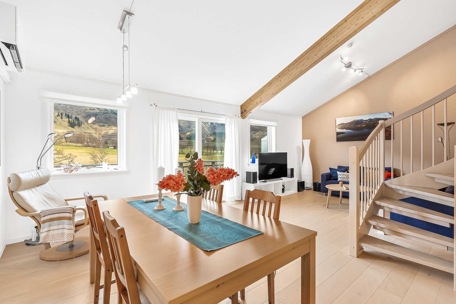 Stuen er lys og innbydende, med et moderne preg og gode møbleringsmuligheter for både sofagruppe, spisebord og annet interiør Galleribilde