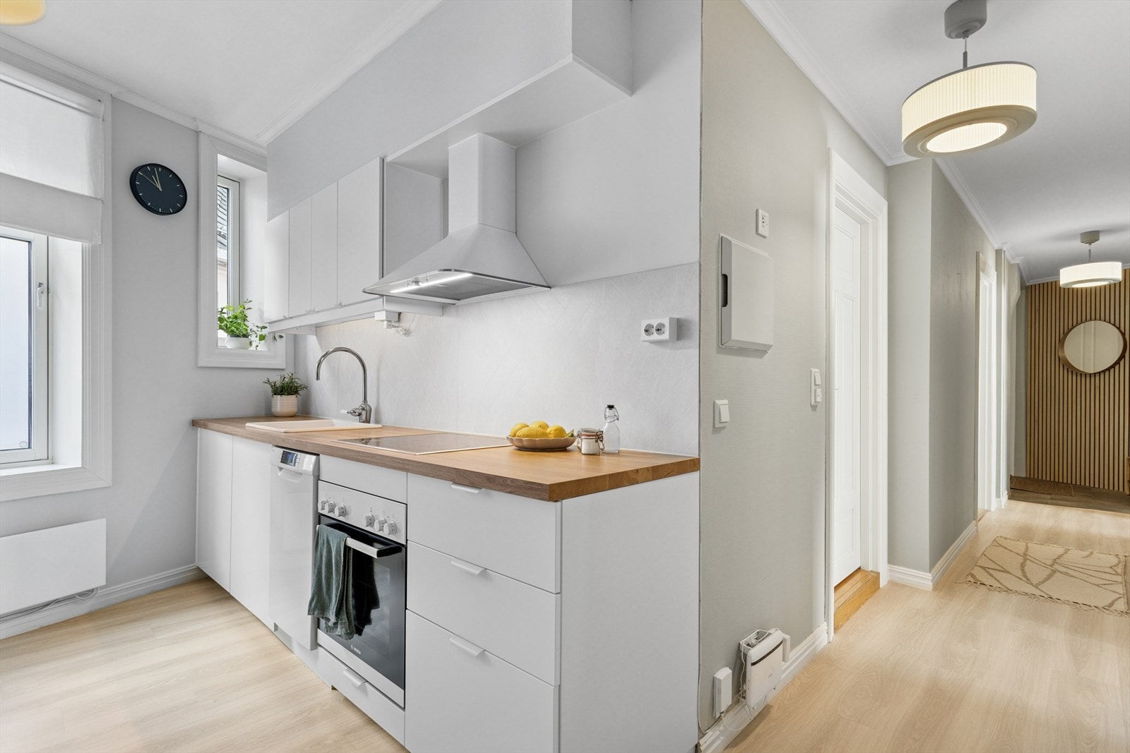 Kjøkkeninnredning med glatte fronter og benkeplate av laminat. Integrerte hvitevarer som stekeovn, platetopp, oppvaskmaskin. Frittstående kjøleskap. Kjøkken og gang har nye gulv fra 2024. Galleribilde