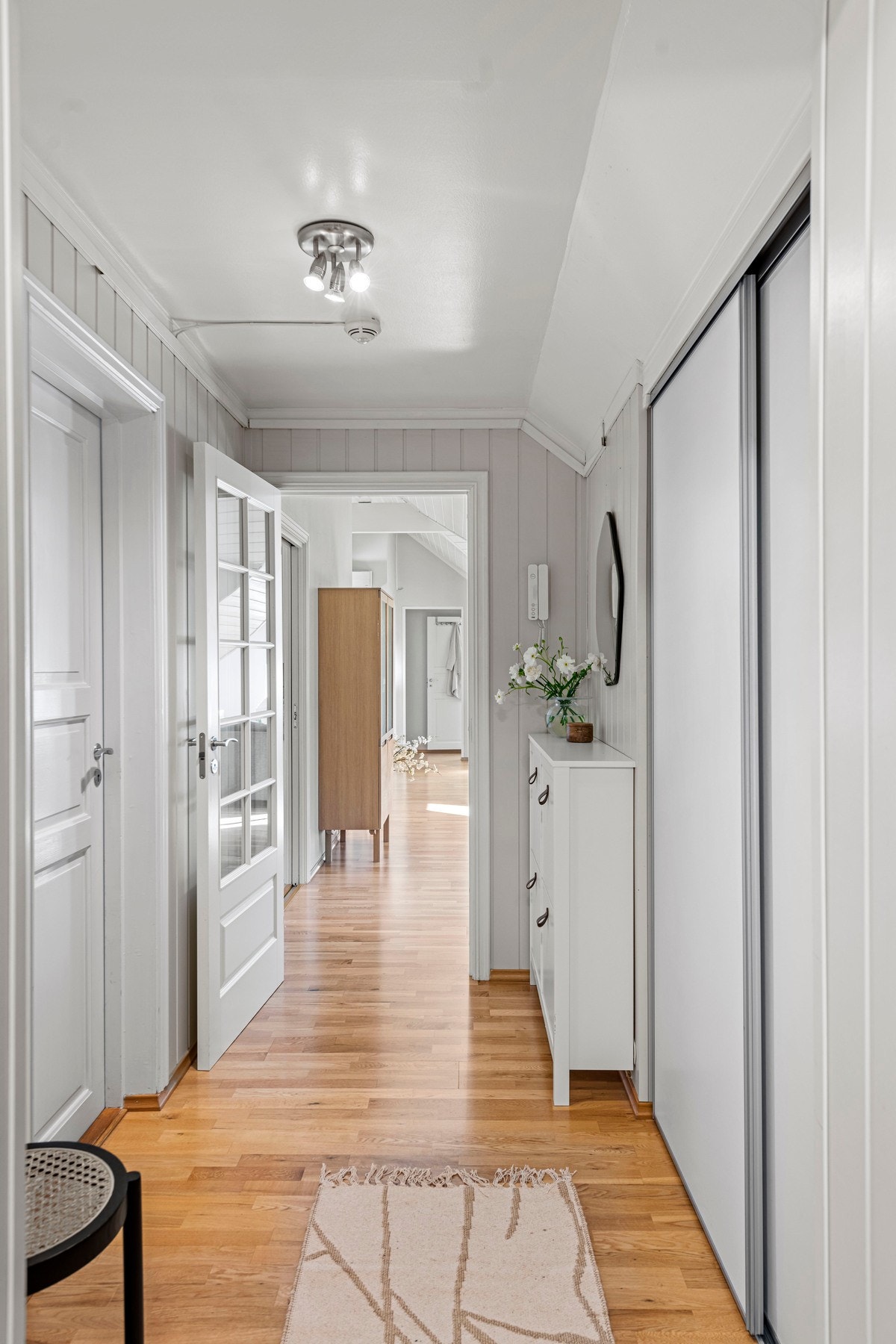 Entreen har en romslig skyvedørsgarderobe fra Elfa med hvite fronter og ekstra god plass, siden det er kott i bakkant. Entreen har ellers fin plass til både kommode og konsollbord. Galleribilde
