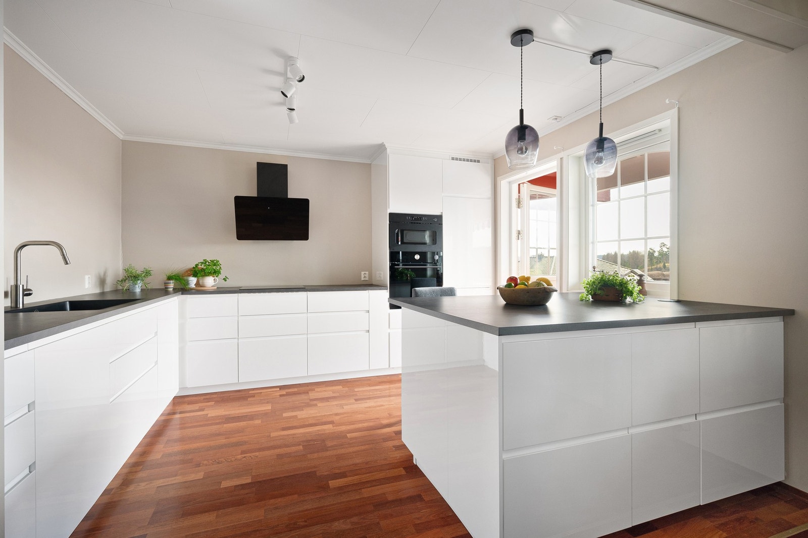 Innredningen er fra 2022 med lyse, slette fronter og laminerte benkeplater i svart kompositt. Galleribilde