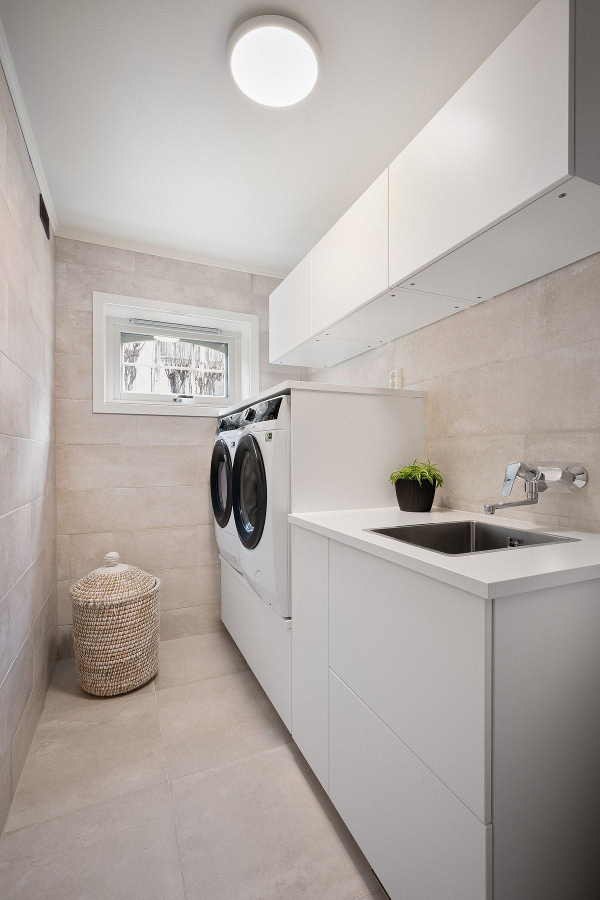 Vaskerommet har praktisk innredning for vaskemaskin og oppbevaring. Galleribilde
