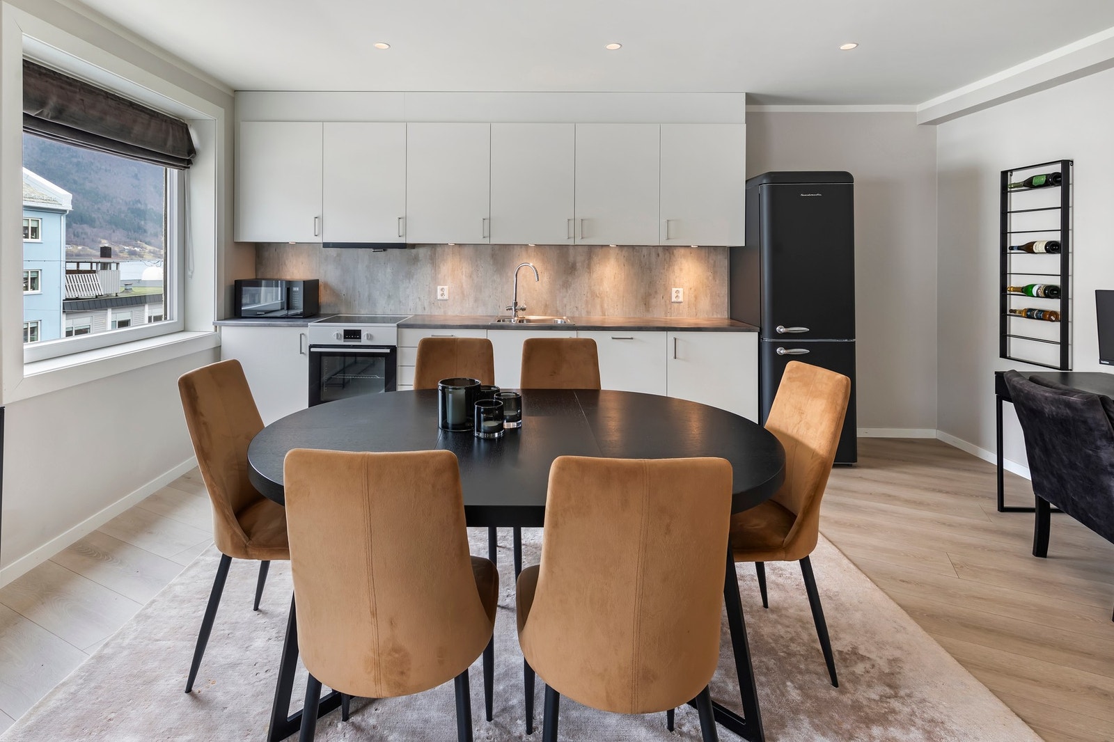 Kjøkkenet har glatte fronter og takhøye overskap Galleribilde