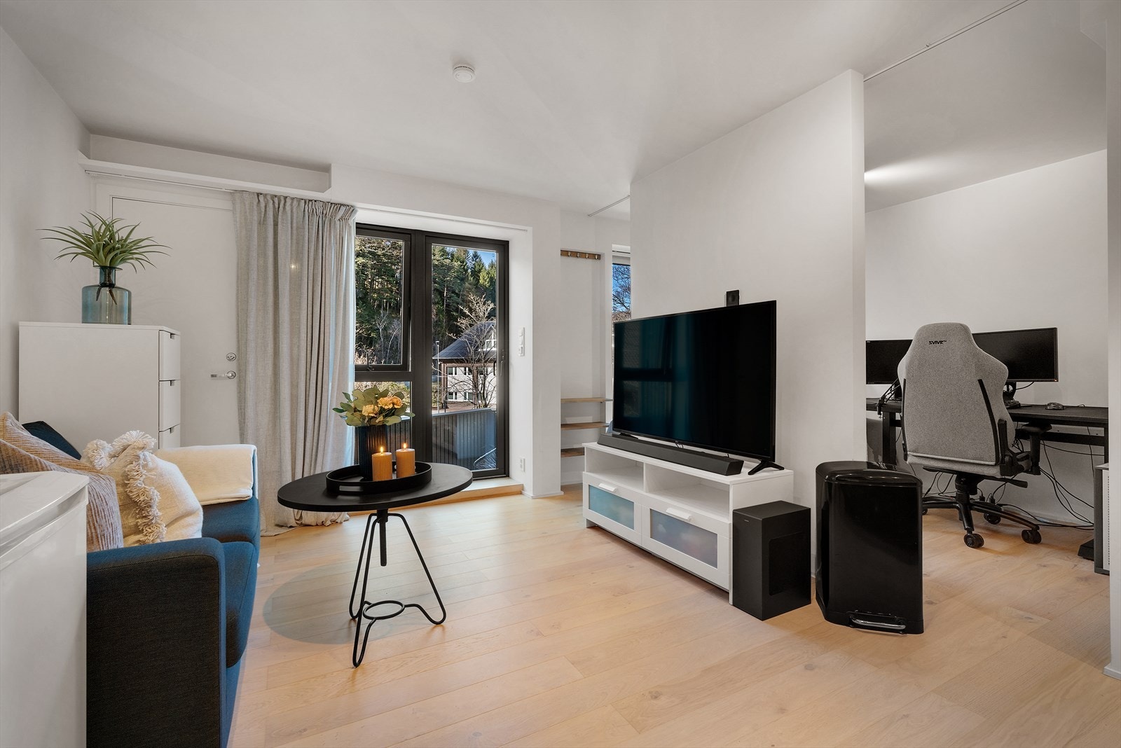 Stue/kjøkkenløsningen har parkett på gulv og malte slette vegger, som skaper et moderne og innbydende miljø Galleribilde