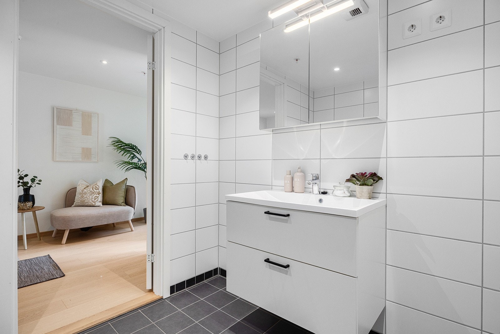 Badet består av enkel servant, speil med belysning, inn -og utadslående dusjdører, vegghengt wc og oppplegg for vaskemaskin. Galleribilde