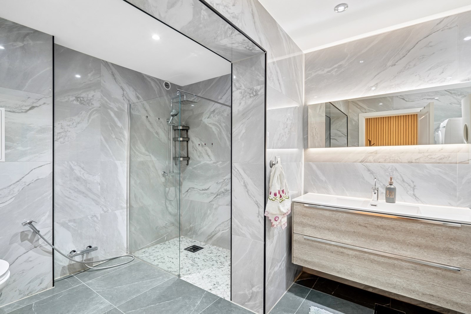 Utsyrt med veggmonterte dusjvegger, dusj direkte på gulv med termostat batteri, veggmontert klosett. Galleribilde