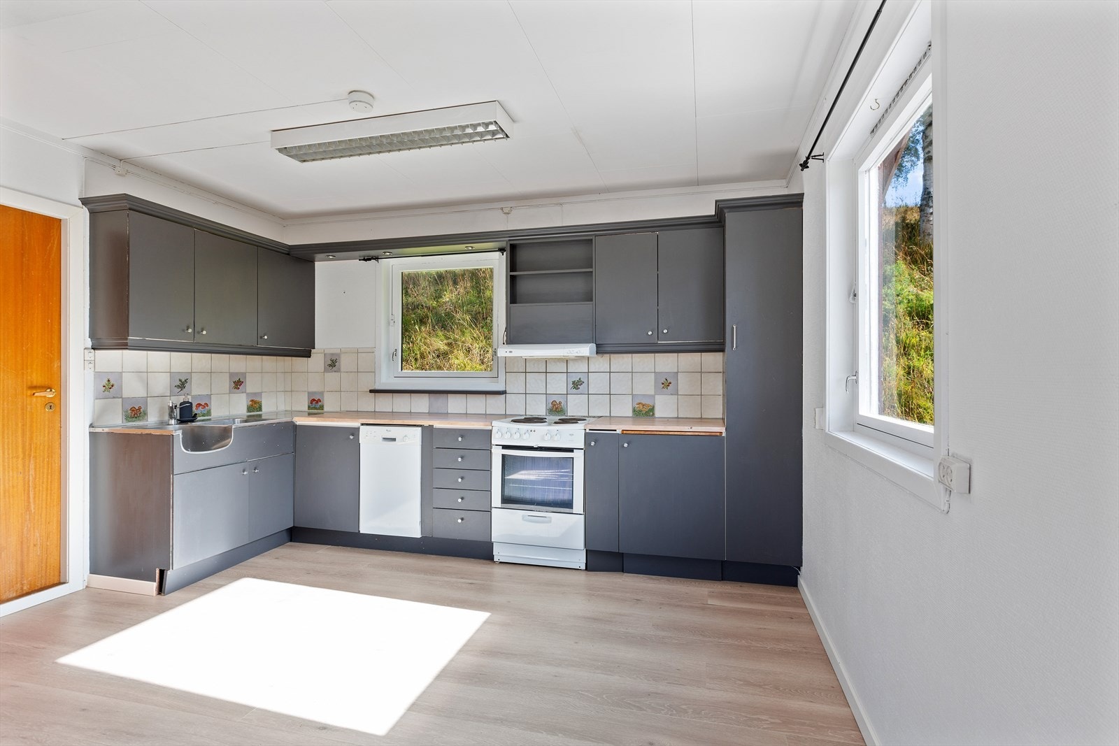 Kjøkken i kårboligen med kjøkkeninnredning med glatte fronter, i laminert skrog og med heltre benkeplate. Galleribilde