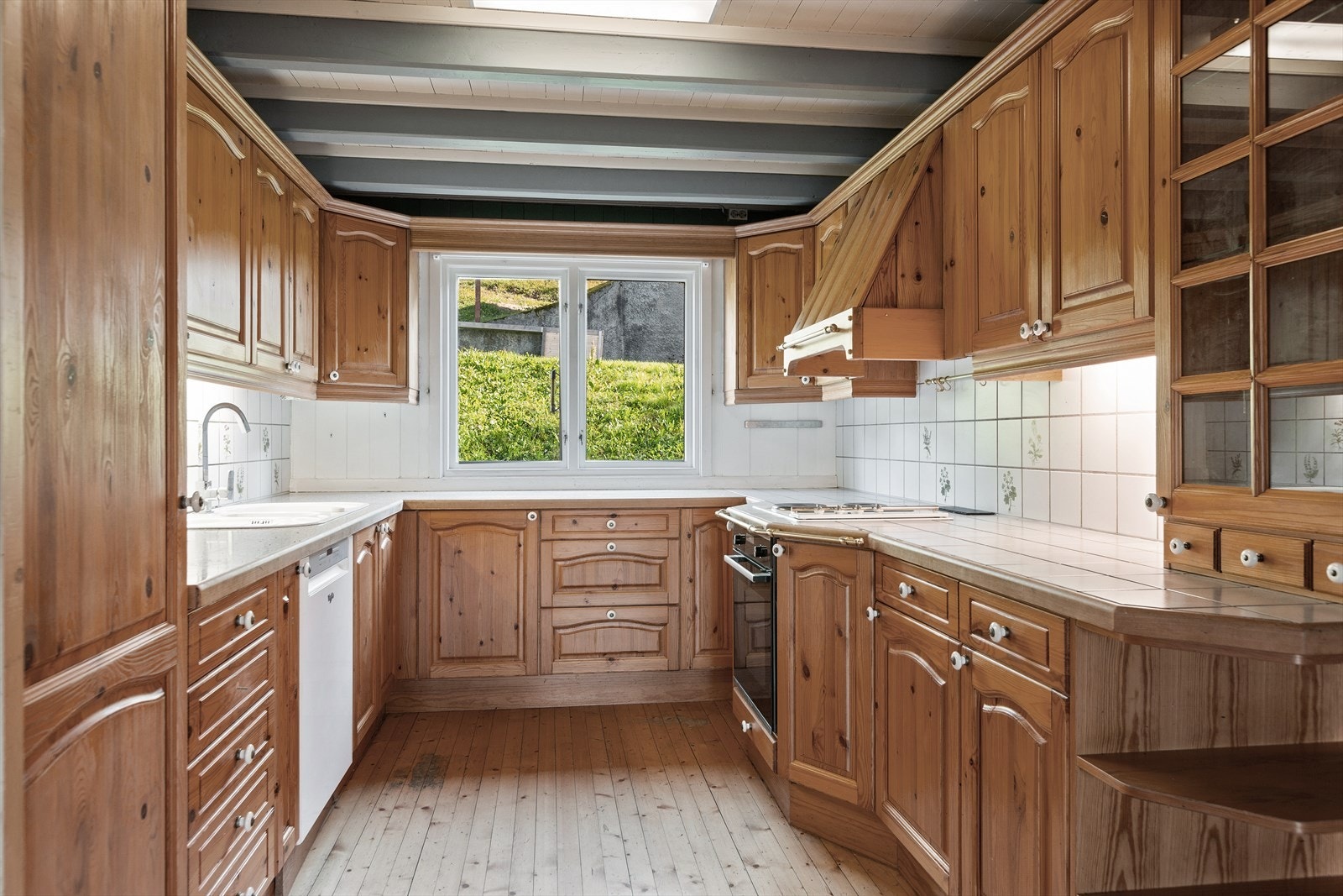 Romslig kjøkken i våningshuset med kjøkkeninnredning med profilerte fronter, i laminert skrog og med laminert benkeplate. Galleribilde