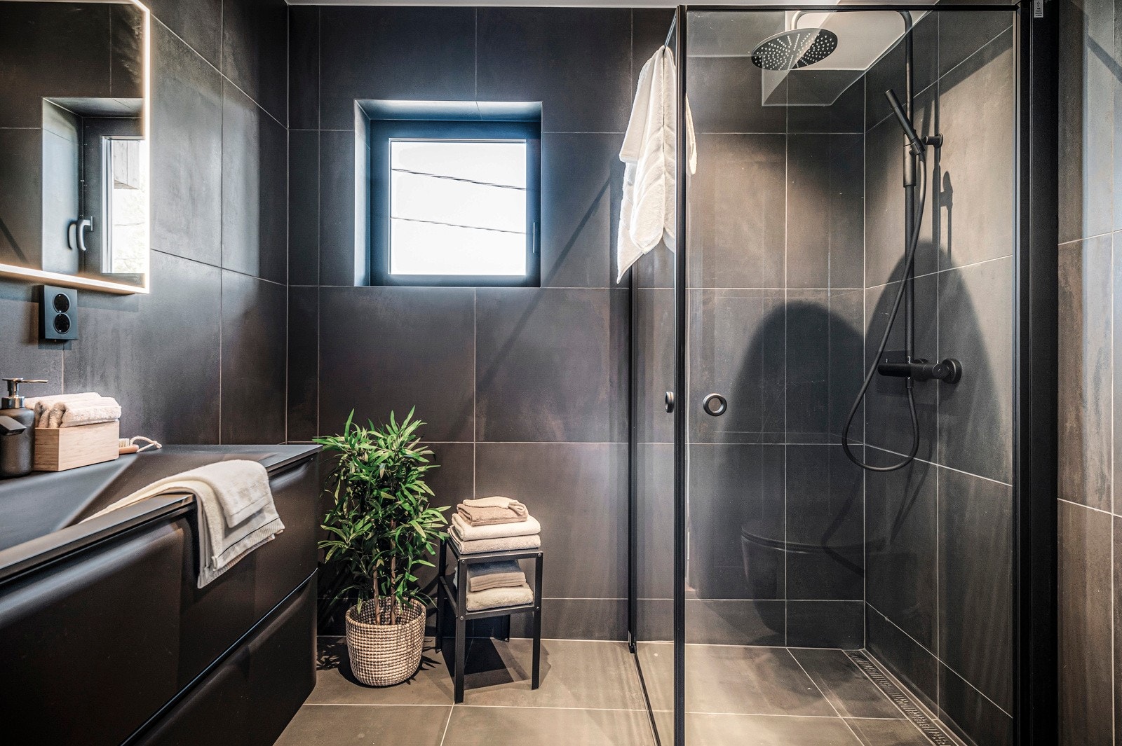 Flott bad i boligens 1. etasje. Badet har delikate storformatfliser på gulv- og veggflater, samt vannbåren varme i gulv. Innredningen består av moderne servantmøblement, speil m/integrert LED belysning, vegghengt toalett og separat dusjsone. Galleribilde