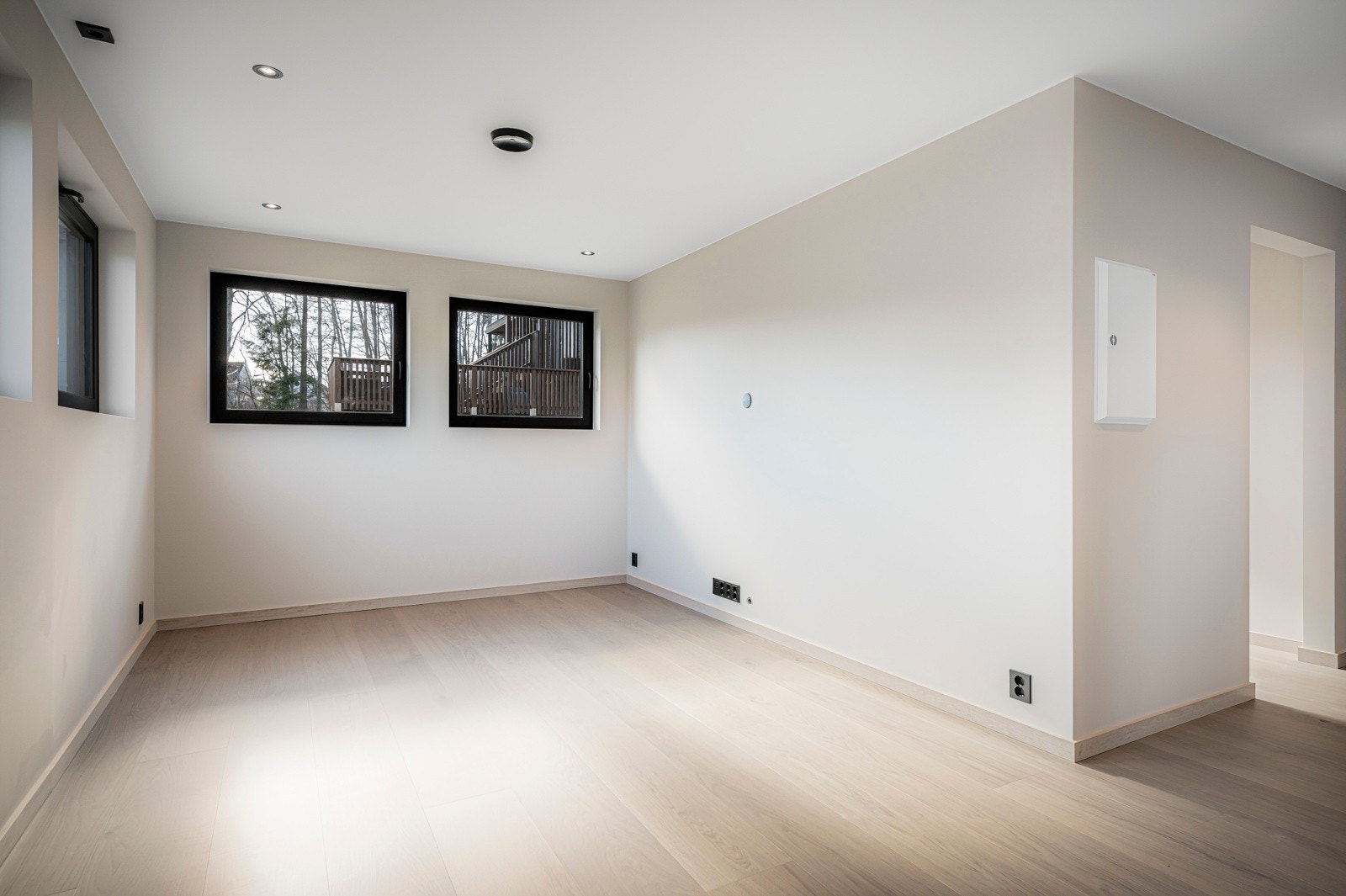 Hybel: Tiltalende stue med malte slette veggflater og lyspigmentert parkett på gulv med vannbåren varme. Himlingen er pent lyssatt med downlights. Gode vindusflater slipper inn godt med lys. Galleribilde