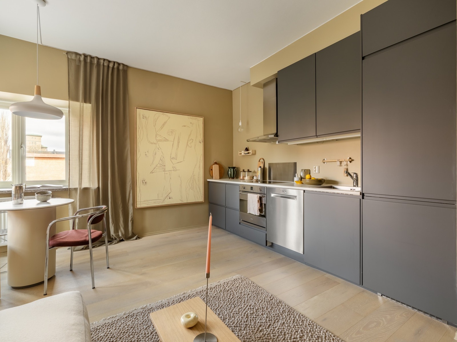 Den åpne kjøkken- og stueløsningen gjør dette til et sosialt allrom og er det naturlige samlingspunktet i leiligheten. Galleribilde