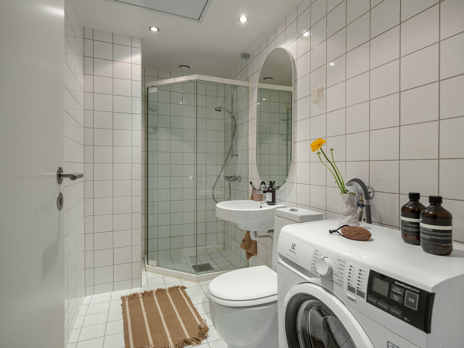 Badet er pent flislagt og er innredet med dusjhjørne, servant med speil på vegg og toalett. Galleribilde