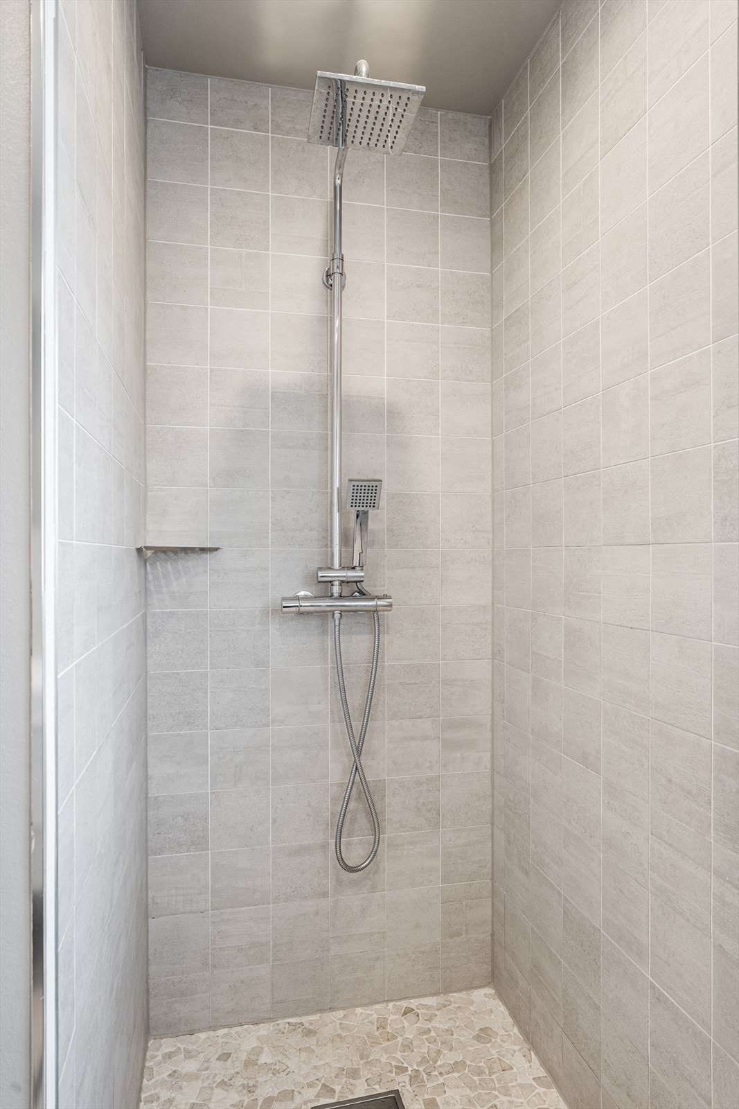 Badet har en stor og flislagt dusjnisje Galleribilde