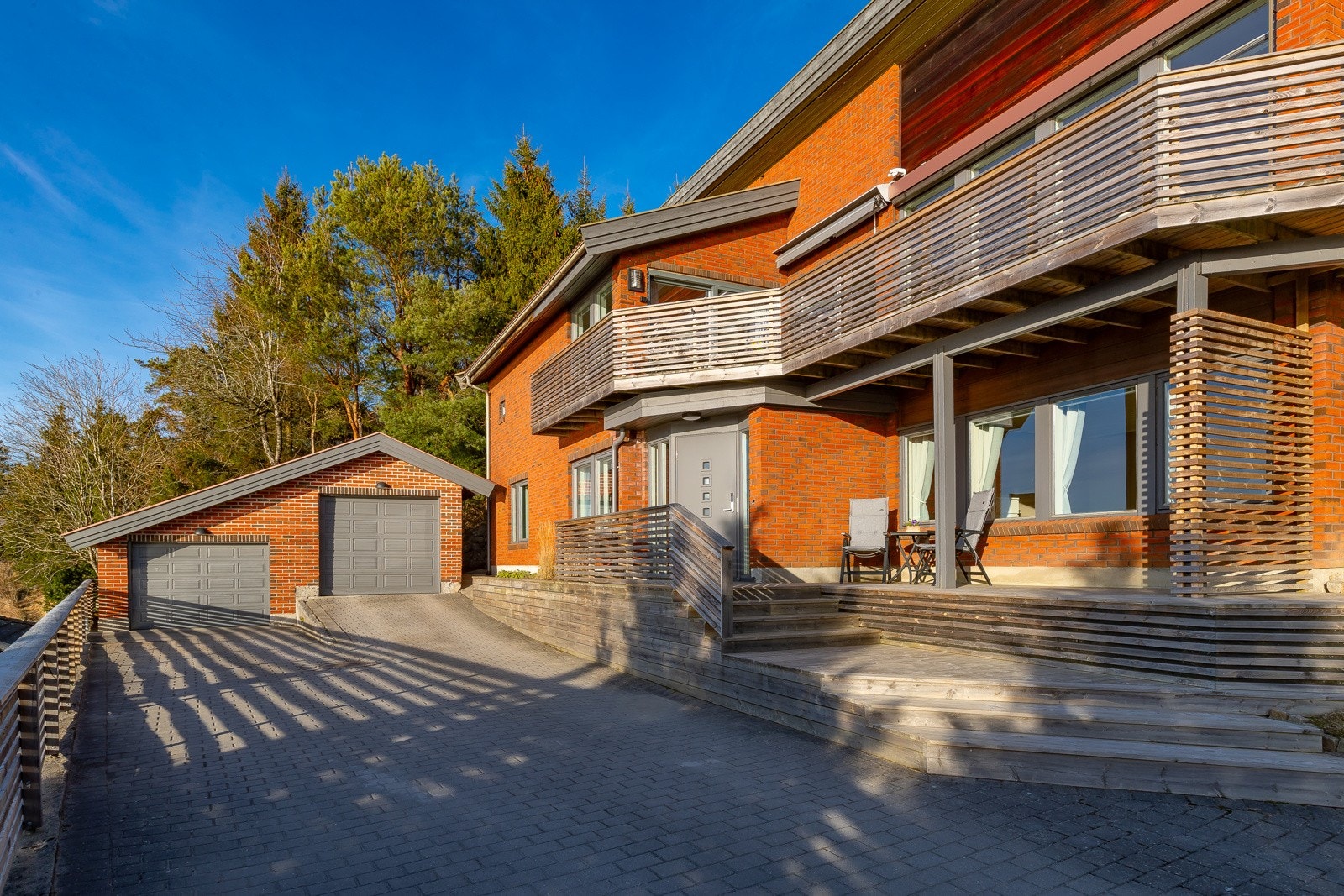 Det er 2 garasjeplasser og romslig gårdsplass som er stenlagt Galleribilde