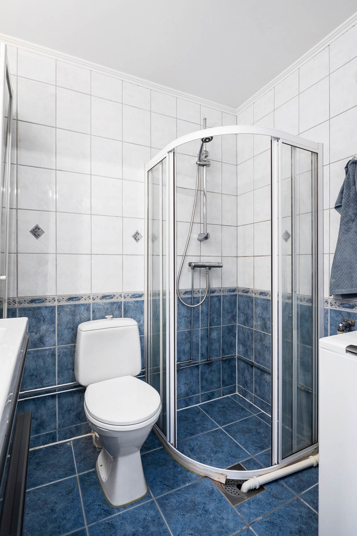 Romslig bad bestående av vegghengt servant med ett-greps armatur. Dusjkabinett med skyvedører av glass og vegghengt hånddusj, gulvstående toalett. Galleribilde