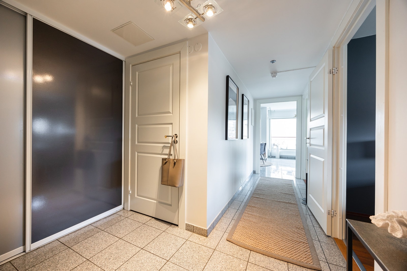 Entréen er praktisk og innbydende, med en skyvedørsgarderobe som gir gode oppbevaringsmuligheter for klær, sko og tilbehør. Galleribilde