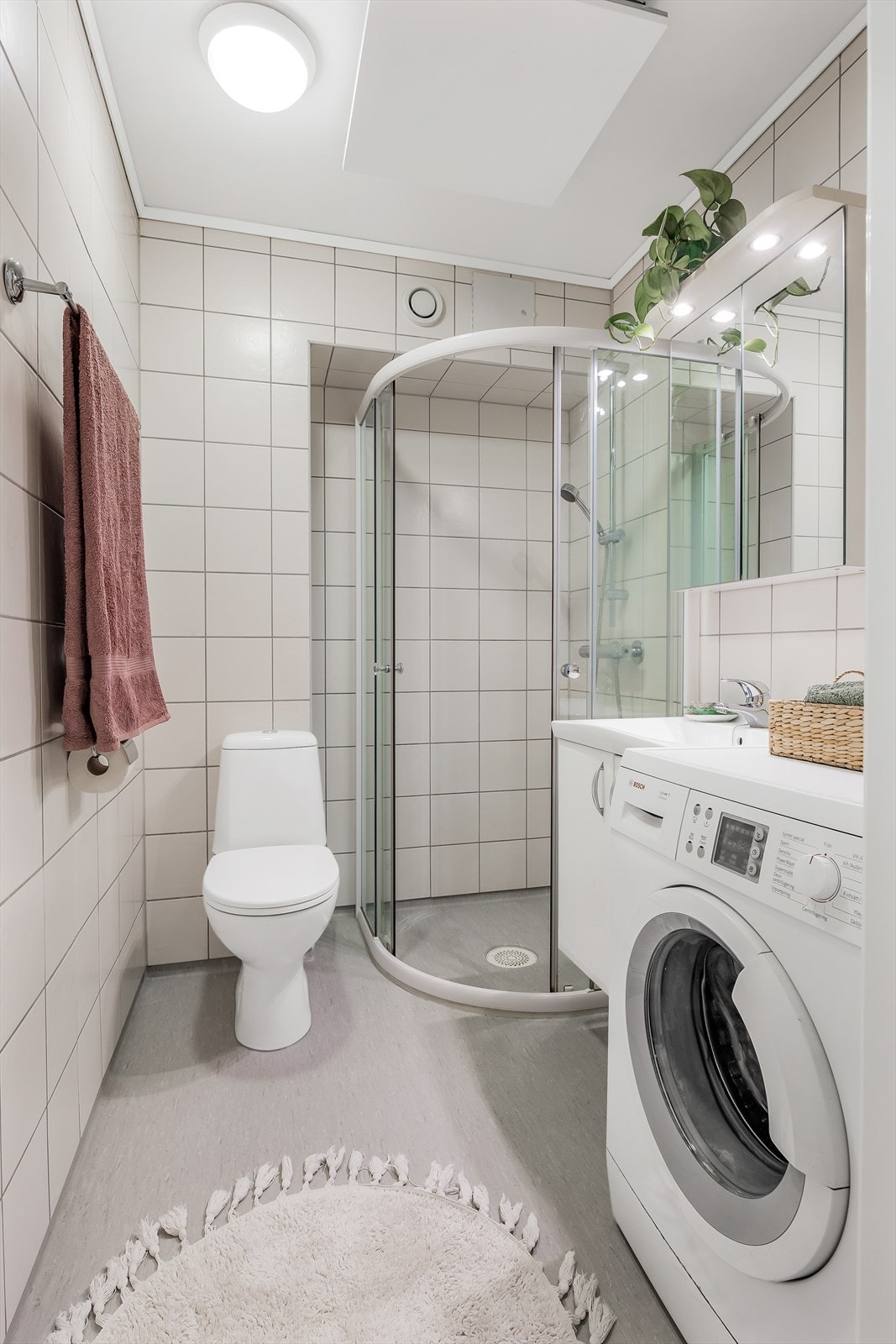Badet er innredet med servant i baderomsinnredning, toalett, dusjhjørne og opplegg for vaskemaskin. Galleribilde