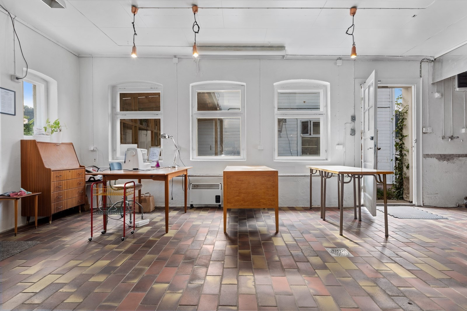Flislagt gulv, høyde under taket og rustikke detaljer skaper et inspirerende miljø for næring eller skapende virksomhet. Galleribilde