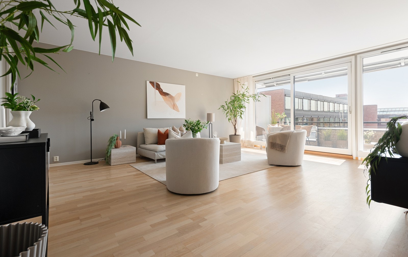De store vindusflatene slipper inn mye naturlig lys og leiligheten oppleves lys og luftig Galleribilde