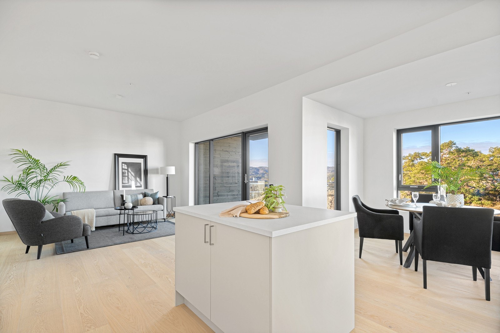 Stue/kjøkken med pent parkettgulv og store vindusflater som slipper inn rikelig med naturlig lys Galleribilde