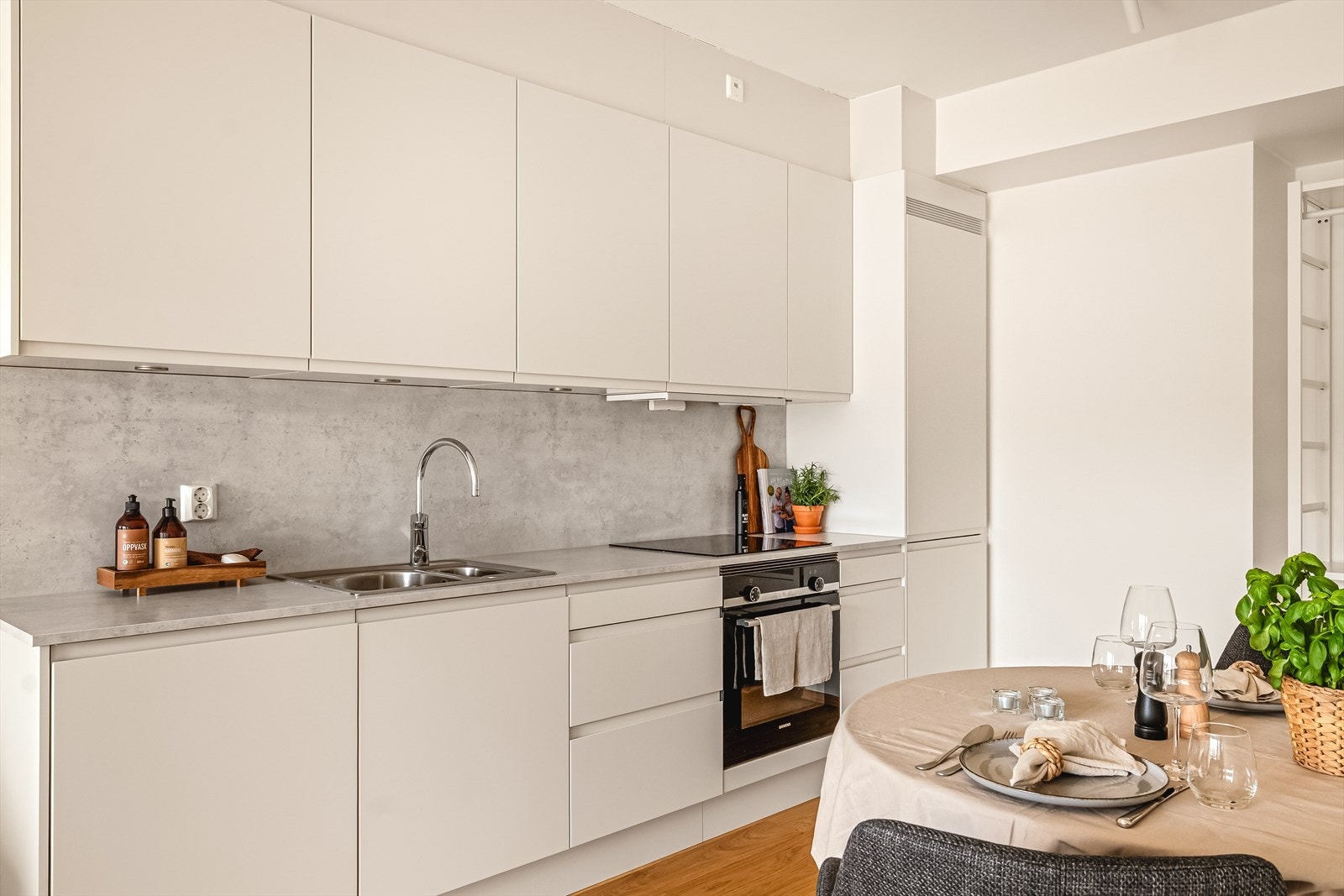 Kjøkkenet er innredet med kjøkkeninnredning fra Sigdal med hvite slette fronter og sort laminat benkeplate. Galleribilde