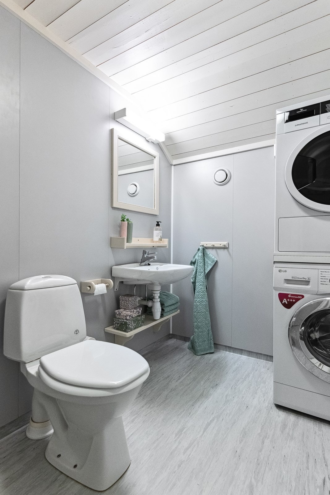 Badet i loftsetg er enkelt innredet m/vask, speil, dusj m/forheng og toalett. Det er opplegg for vaskemaskin/tørketrommel. Galleribilde