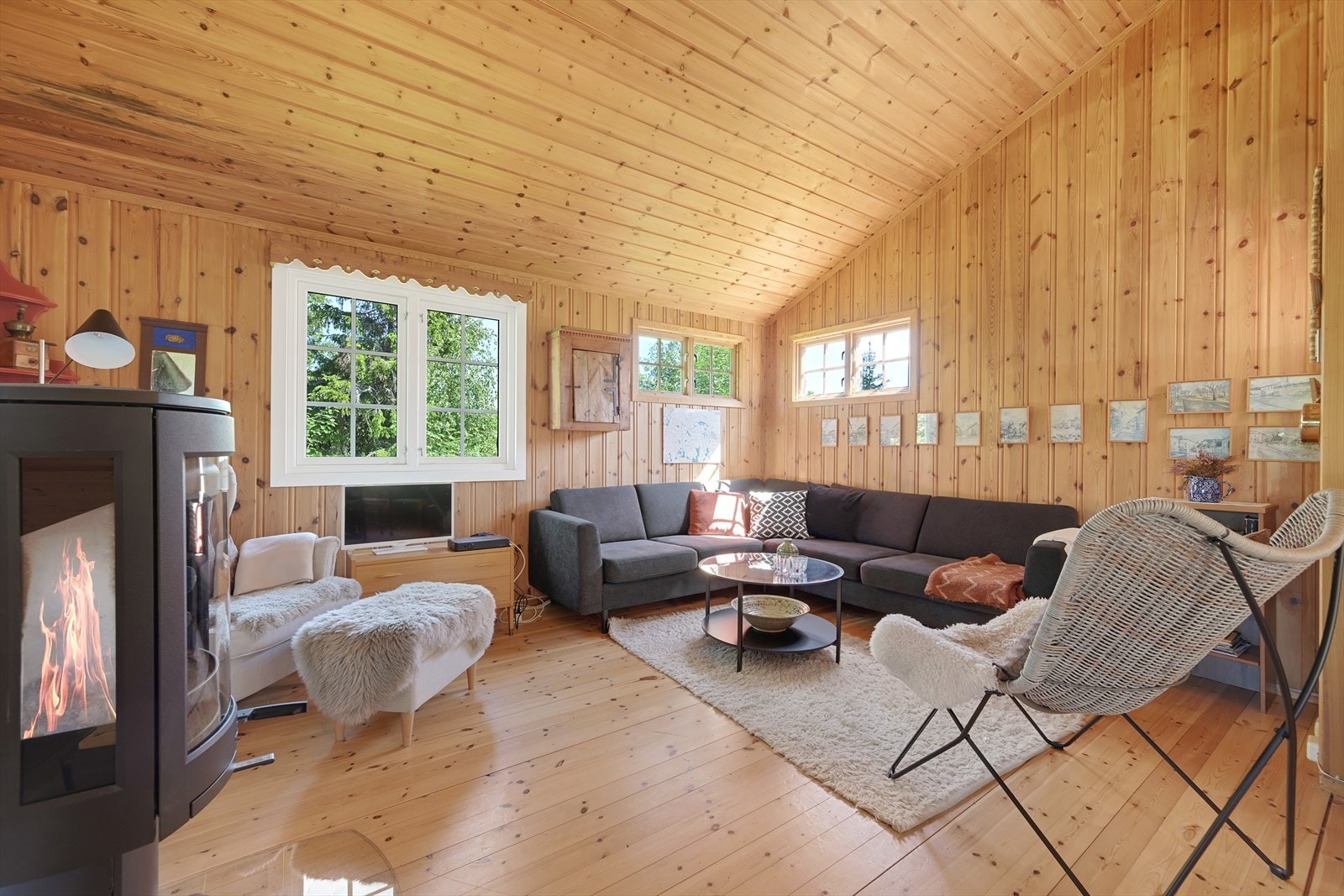 Koselig stue med trepanel på veggene. Nyt varme og hygge fra peisovnen på kalde dager. Galleribilde