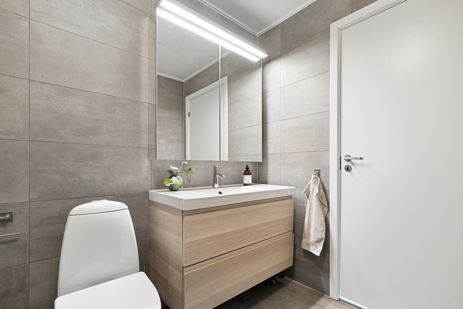 Fargevalgene er tidløse og innbydende. Badet er innredet med dusjhjørne, toalett, servant med underskuffer og speil med skap. Galleribilde
