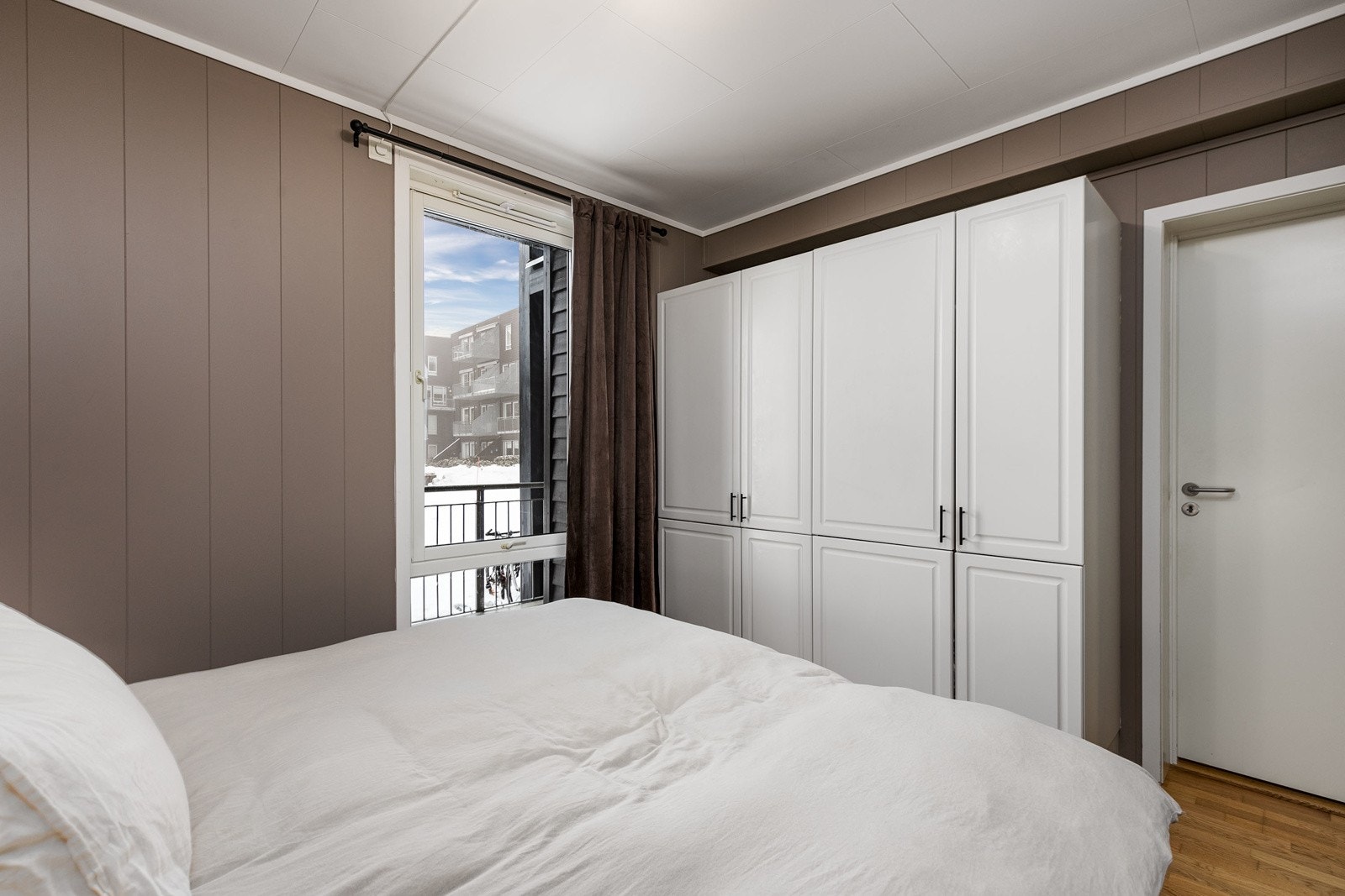 Hovedsoverommet har lyse vegger, trestavs eikeparkett på gulvet og et stort vindu som slipper inn rikelig med lys. Galleribilde