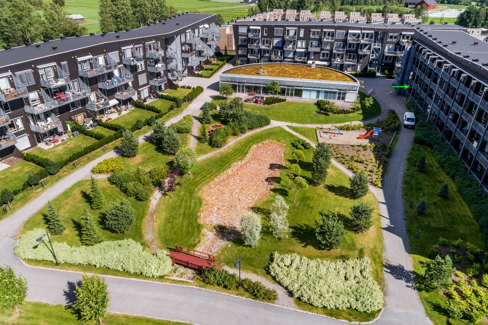 Felles eiet tomt for borettslaget, pent opparbeidet med plen- og grøntområder, beplantninger og prydbusker, lekearealer og plaskedam, samt asfaltert adkomst og gangveier. Galleribilde