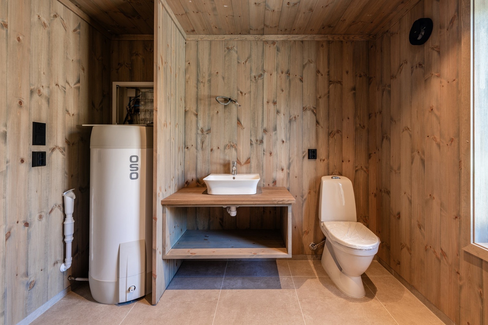 Flott bad med flislagt gulv, plassbygget innredning og 200L OSO varmtmannsbereder Galleribilde