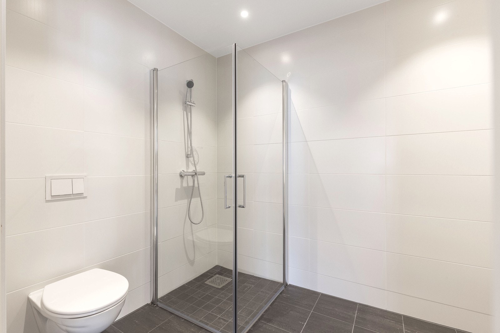 Flisbelagt bad med varmekabler fremstår lyst og tidløst. Galleribilde