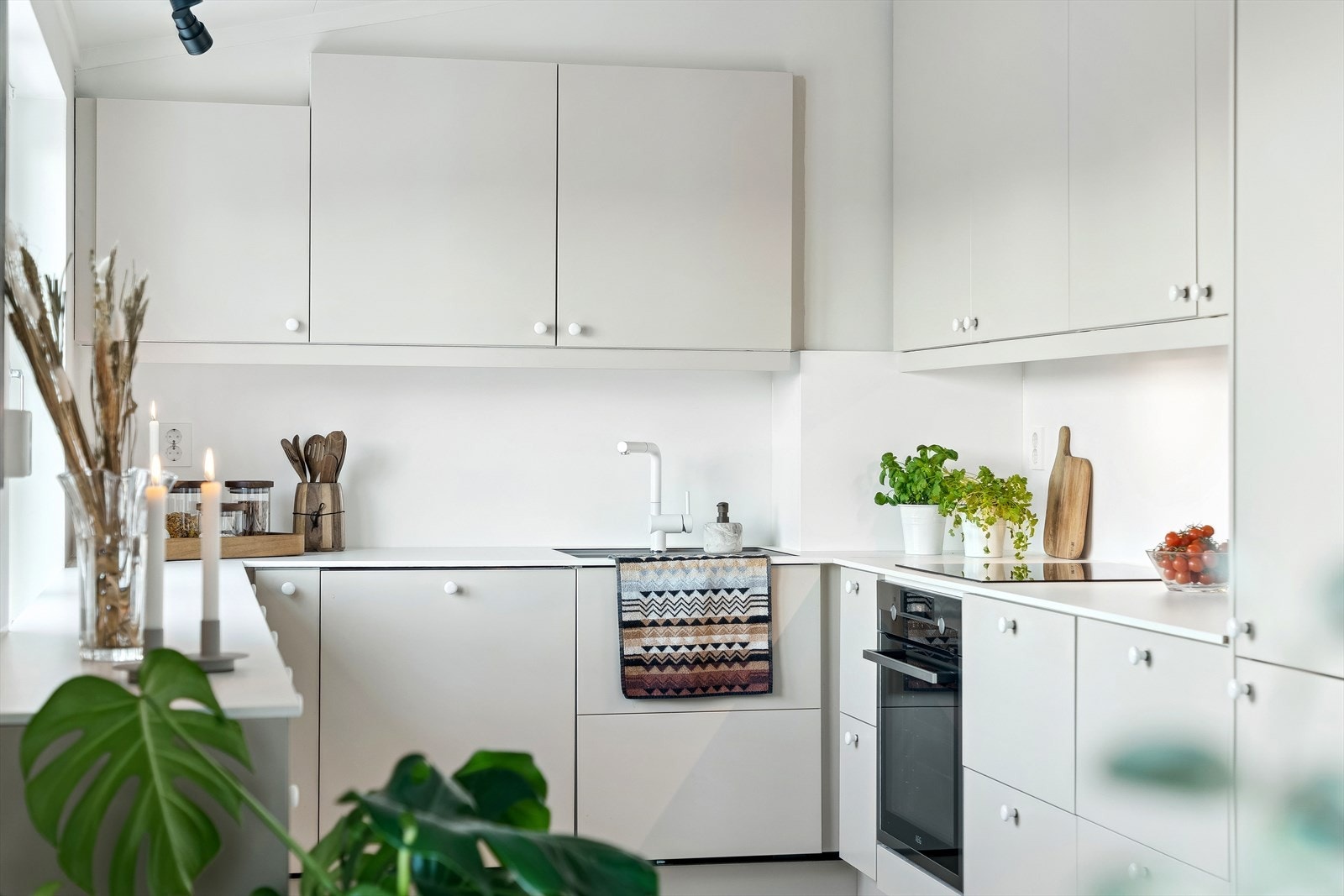 Kjøkkenet er praktisk utformet i en funksjonell U-løsning. Innredningen har lyse fronter kombinert med en tidløs benkeplate som gir et stilrent uttrykk. Galleribilde