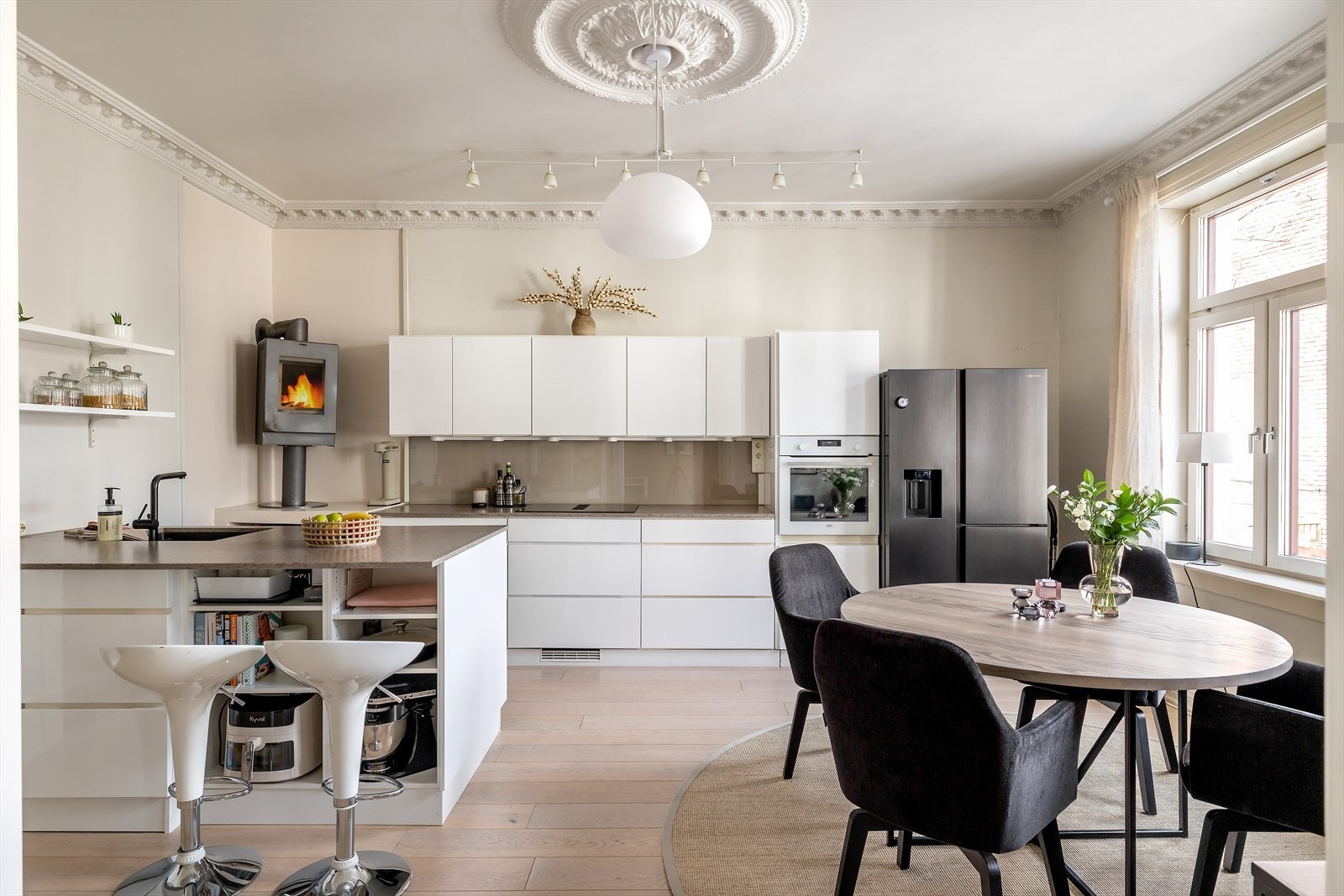 Romslig spisekjøkken med kjøkkenøy, peis og fin plass til spisebord Galleribilde