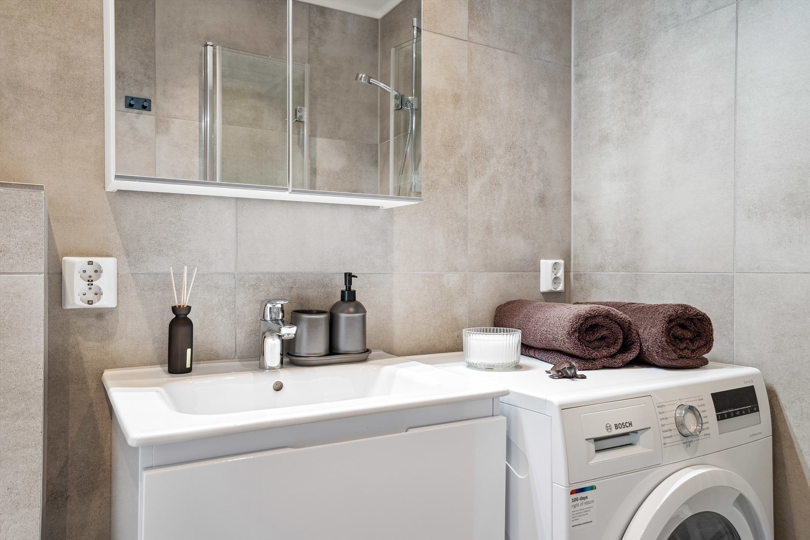 Badet er flislagt med opplegg for vaskemaskin. Galleribilde