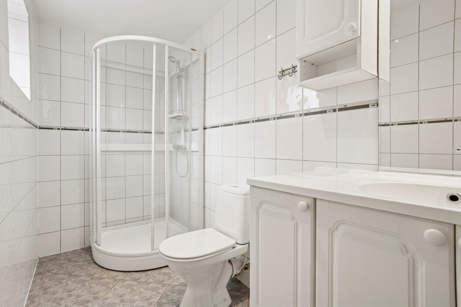Badet holder en enkel og standard utførelse, med flislagte overflater og funksjonelle løsninger.Et greit og brukervennlig bad som fungerer godt i hverdagen Galleribilde