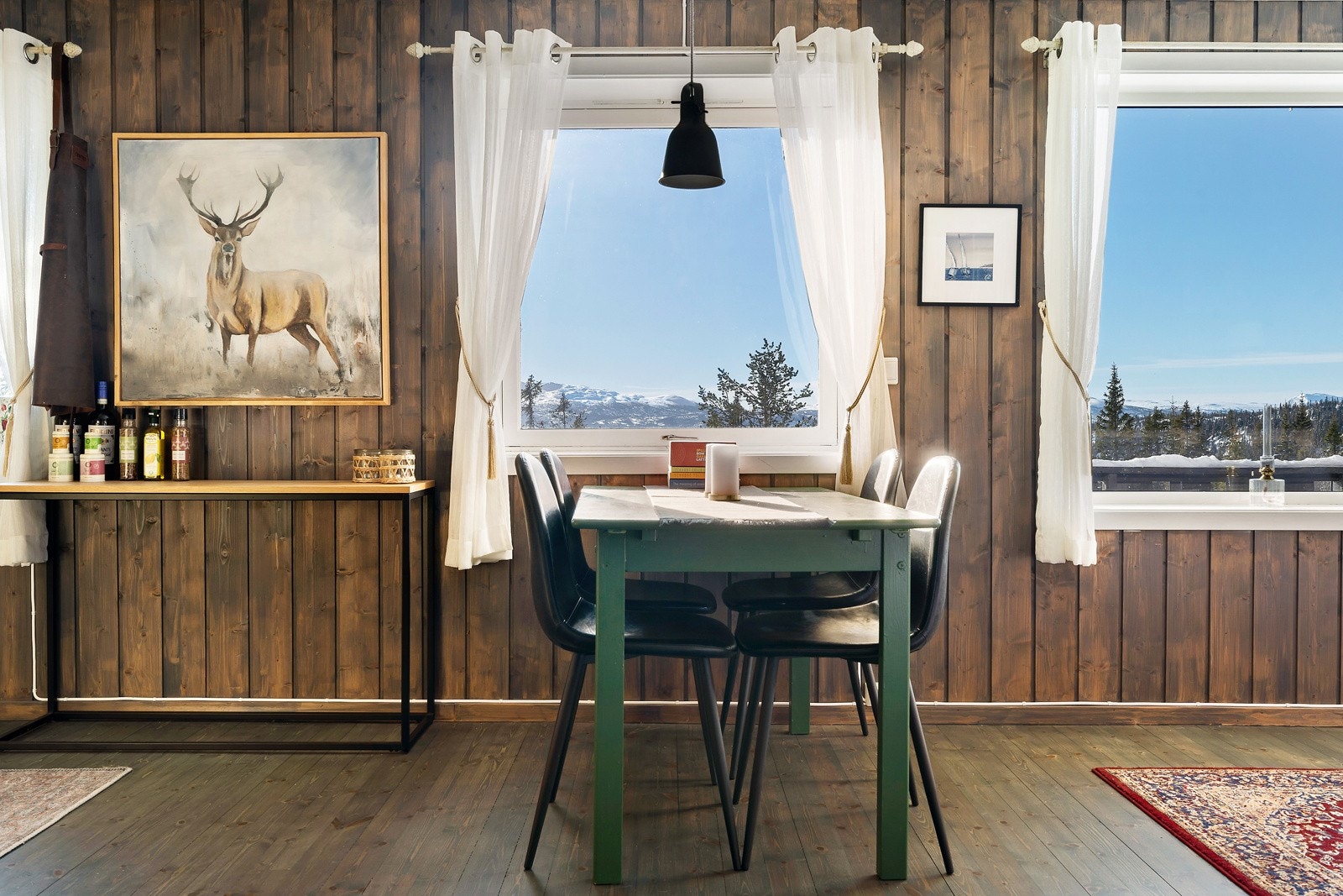 Stuen har store vindusflater som slipper godt med naturlig lys inn Galleribilde