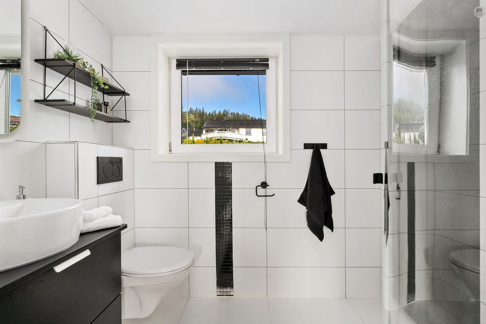 Badet i hoveddel har servant, vegghengt toalett, dusjhjørner og speil med lys. Galleribilde