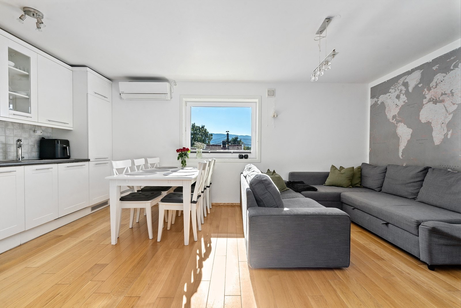 Kjøkken i utleieleilighet. Kjøkkeninnredning med glatte, hvitlakkerte fronter. I to av frontene er det glassfelt. Takhøye overskap. Benkeplate i laminat med nedfelt oppvaskkum. Keramiske fliser mellom benk, og overskapene. Galleribilde