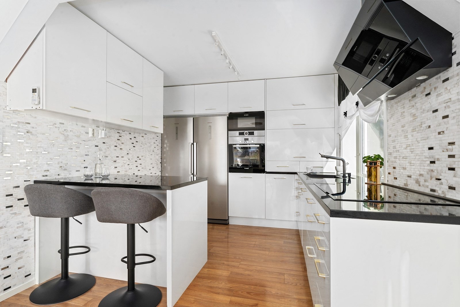 Delikat romslig kjøkken med en øy med barløsning som kan brukes som spiseplass. Galleribilde