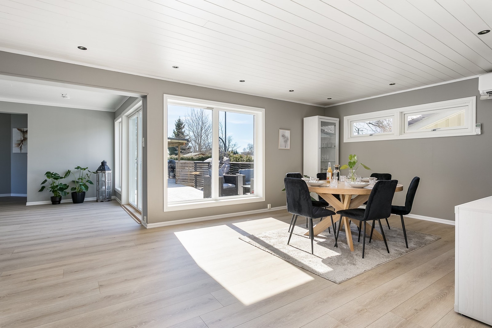En rekke vinduer med til dels store flater fyller stuen med både solstråler og mye naturlig dagslys. Galleribilde