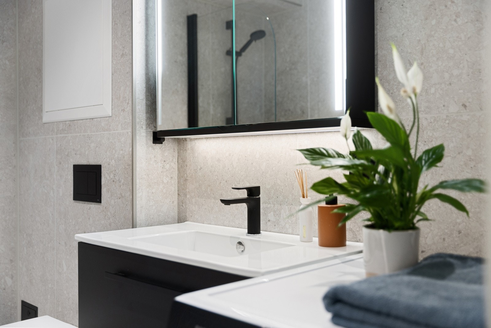 Badet er innredet med badekar, servant, opplegg for vaskemaskin og vegghengt toalett Galleribilde