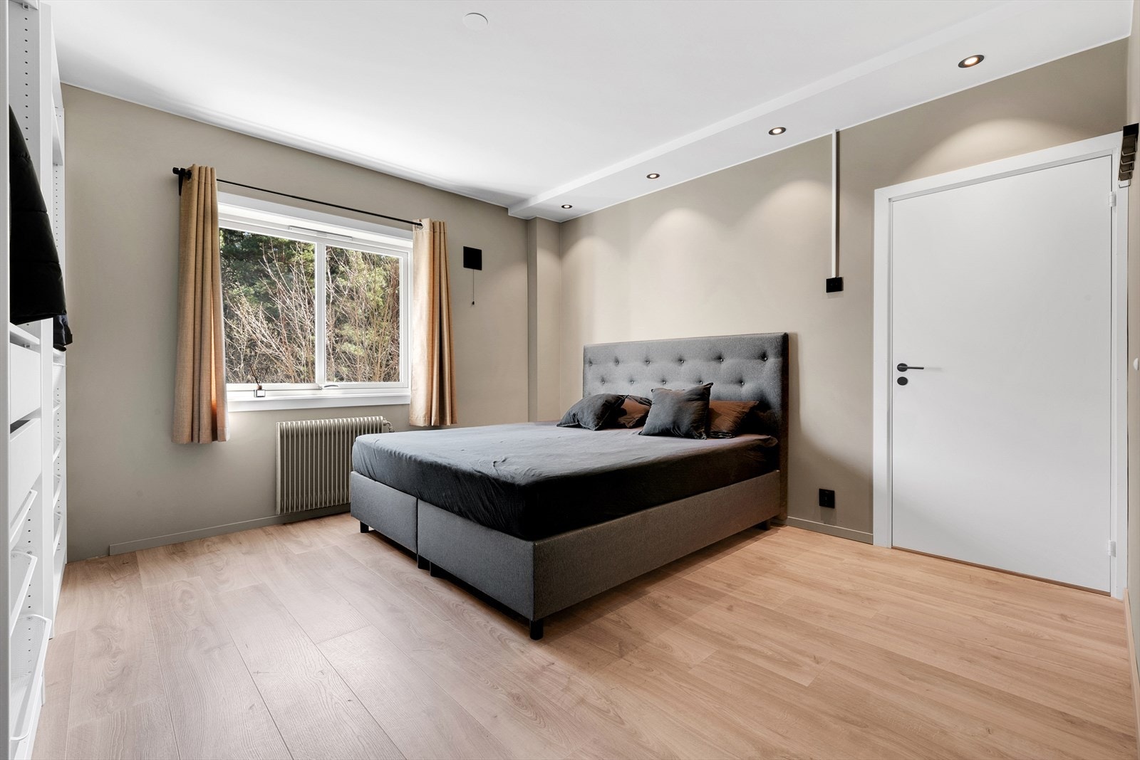 Soverom 1 med laminat på gulv, malte slette vegger og malt tak. Det er montert downlights og 2. stk åpne Ikea garderobeskap med oppheng, skuffer og kurver. Rommet har også inngang til en praktisk bod. Galleribilde